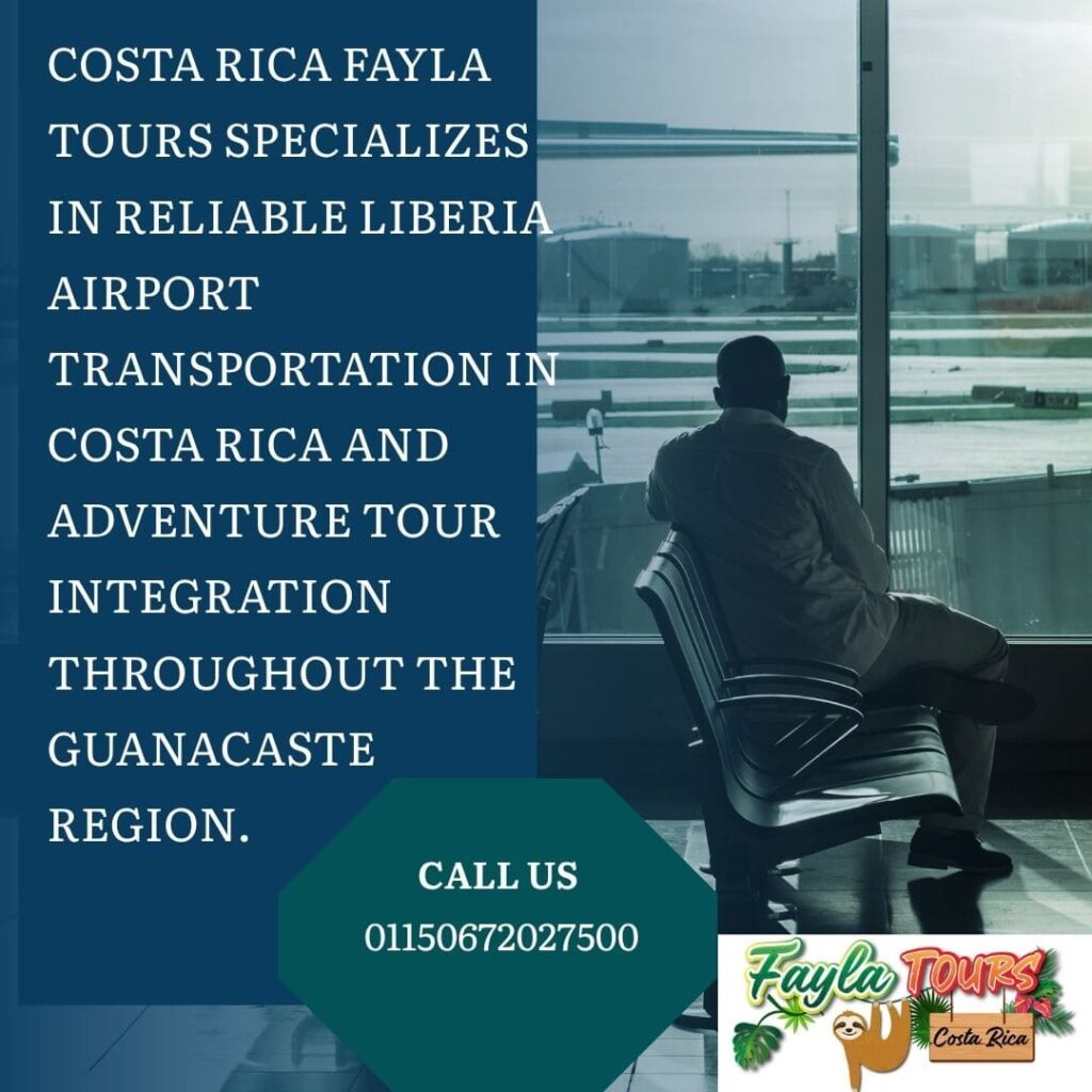 A man sits in an airport terminal looking out a large window at what appears to be an airport tarmac with industrial tanks in the background.